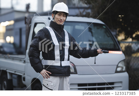 A young man directing traffic 123317385
