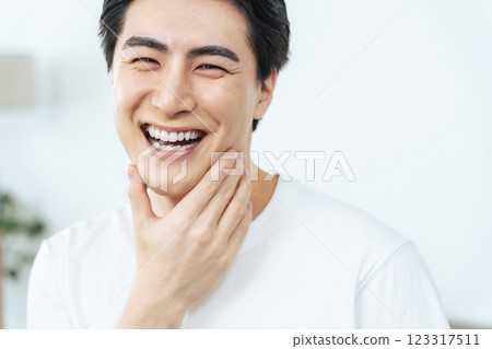 Young man smiling and showing white teeth Young man smiling and showing white teeth 123317511