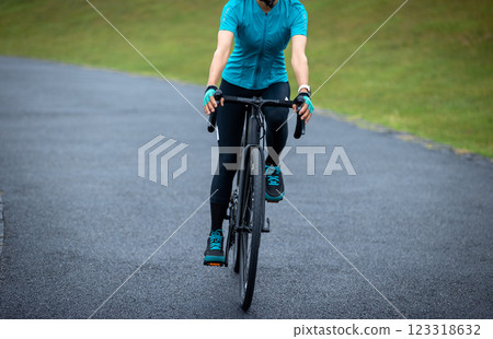 Woman biking on summer park trail Woman biking on summer park trail 123318632