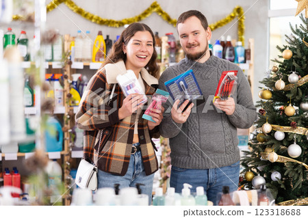 Happy couple choosing razors in Christmas decorated personal care store 123318688