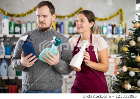 Woman seller offers cleaning spray to young man buyer Woman seller offers cleaning spray to young man buyer 123318886