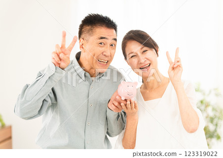 Mature couple holding a piggy bank Mature couple holding a piggy bank 123319022