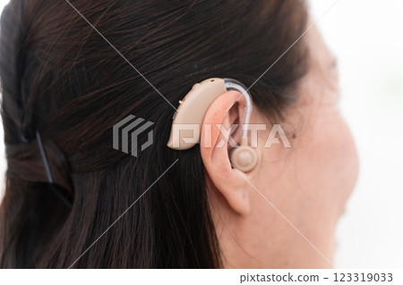 Mature woman wearing a hearing aid 123319033