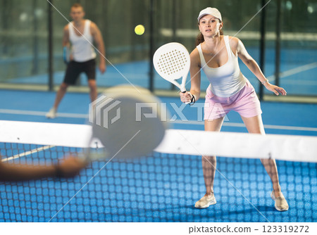 Adult woman and young man playing tennis against woman 123319272