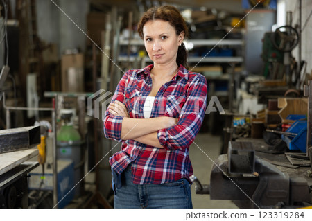 Portrait of confident female worker in workshop of metallurgical plant Portrait of confident female worker in workshop of metallurgical plant 123319284