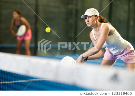 Young and adult women playing doubles tennis 123319400