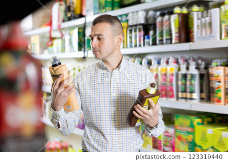Young man choosing fertilizers in store Young man choosing fertilizers in store 123319440