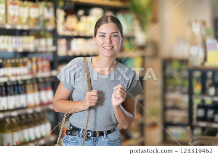 Girl in bio supermarket sales area looks into distance and searches for necessary goods 123319462