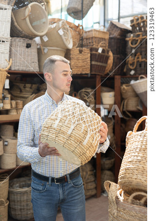 Man looks at wicker basket in store. 123319463