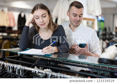 Man with phone in hands participates in discussion of business development plans with wife Man with phone in hands participates in discussion of business development plans with wife 123319529