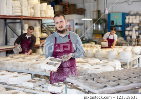 Young man showing poured clay molds 123319633