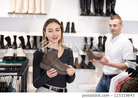 Young woman choosing boots in shoe store 123319645