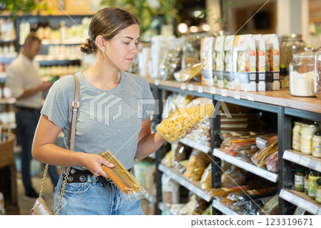 Young girl purchaser buying pasta in grocery store Young girl purchaser buying pasta in grocery store 123319671