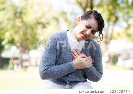 Caucasian woman chest pain in outdoor park, emergency of patient with injury. Caucasian woman chest pain in outdoor park, emergency of patient with injury. 123320774