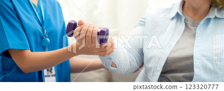 Asian caregiver woman or nurse training senior woman lifting dumbbell for arm exercise. 123320777
