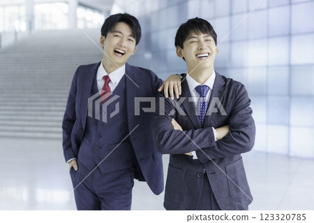 兩位友善的年輕商人站在辦公大樓樓梯前的畫像 123320785