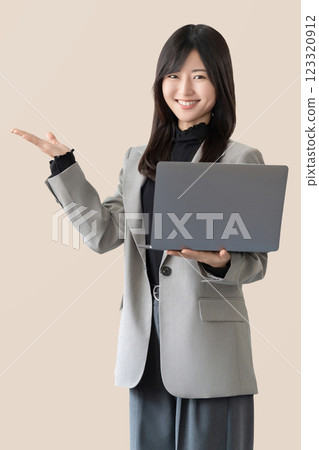 一位微笑的女人/女商人拿著筆記型電腦指路 123320912