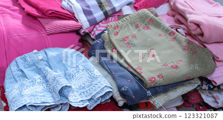 Stack of baby clothes in pink and postel colors. Cleaning and recycling. Ecology and upcycle. 123321087