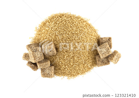 A heap of raw brown sugar with brown sugar cubes arranged symmetrically against a white background. 123321410