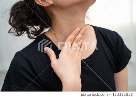 Asian woman touching her neck and throat for thyroid gland problem. 123321838