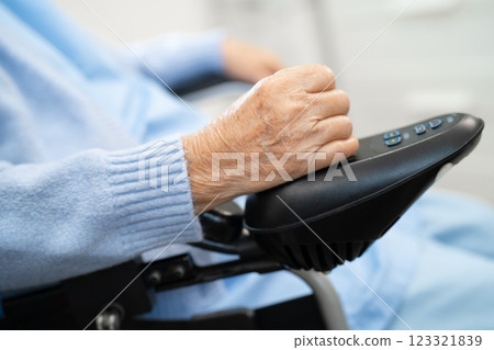 Asian senior woman patient on electric wheelchair with remote control at hospital, healthy strong medical. 123321839