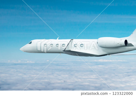 White modern luxury executive business jet flies in the air above the clouds 123322000