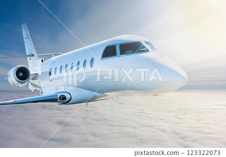 White modern luxury private jet flies in the air above the clouds. Close-up view business airplane White modern luxury private jet flies in the air above the clouds. Close-up view business airplane 123322073