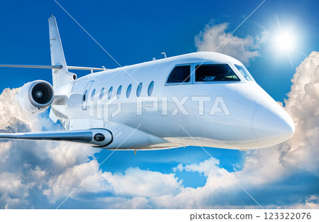 Close-up view of white luxury corporate airplane flies in the air above the clouds Close-up view of white luxury corporate airplane flies in the air above the clouds 123322076