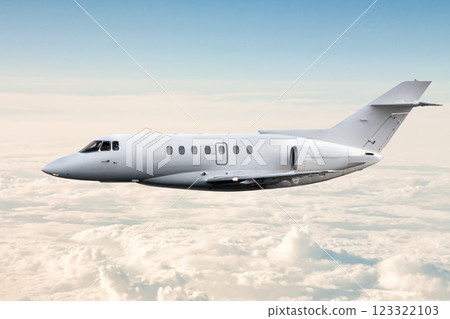 White modern luxury private jet flies in the air above the clouds White modern luxury private jet flies in the air above the clouds 123322103