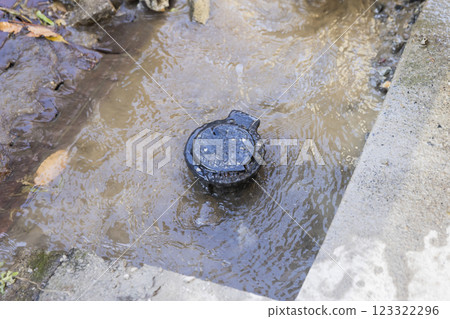 The state where the concrete has been removed from the area where the water pipe has burst and water is overflowing from the stop valve. 123322296