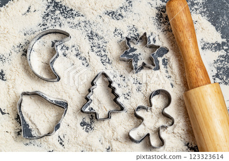 Christmas baking prep! Cookie cutters, rolling pin, and flour on a dark background. Holiday baking season 123323614