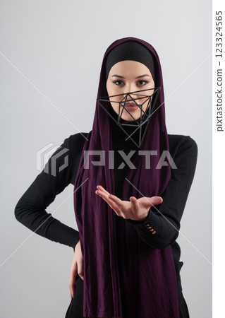 Elegant Muslim woman in a hijab with a geometric structure in a conceptual portrait. Elegant Muslim woman in a hijab with a geometric structure in a conceptual portrait. 123324565