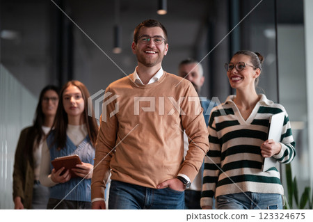 Business team in a modern open space startup office walking together. Diverse group of businesspeople smiling while having a discussion. Successful mixed race colleagues collaborating on a new project Business team in a modern open space startup office walking together. Diverse group of businesspeople smiling while having a discussion. Successful mixed race colleagues collaborating on a new project 123324675
