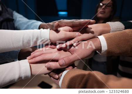 Business professionals stacking hands in support of collaboration, inclusion, and equality in the office. The workplace community huddles together for solidarity, cooperation, and team building. Business professionals stacking hands in support of collaboration, inclusion, and equality in the office. The workplace community huddles together for solidarity, cooperation, and team building. 123324680