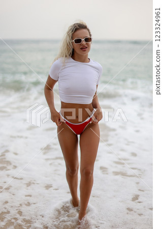 A model posing in stylish swimwear by the beautiful beach, capturing the vibrant summer vibes 123324961