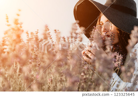 Woman in Hat Inhaling the Fragrance of Lavender Field 123325645