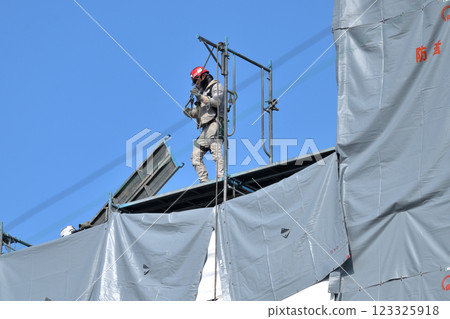 Construction site: Scaffolders dismantling temporary scaffolding Construction site: Scaffolders dismantling temporary scaffolding 123325918