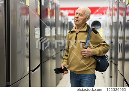 Senor man pensioner buying fridge in showroom of electrical appliance store 123326963