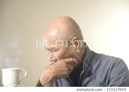 Steaming hot drink and troubled old man 123327654