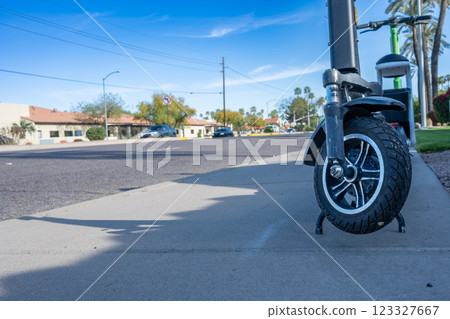Selective focus on front wheel of a rental electric scooter in Phoenix, Arizona Selective focus on front wheel of a rental electric scooter in Phoenix, Arizona 123327667