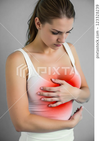 Woman experiencing chest pain while standing indoors in a casual outfit during daylight 123328239