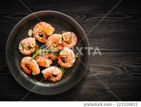 Grilled prawn shrimps in pan on wooden table Grilled prawn shrimps in pan on wooden table 123328631