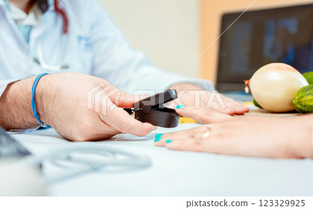 Hand of nutritionist using oximeter on finger of female patient. Close up of hands of nutritionist using pulse oximeter on patient finger. Nutritionist measuring oxygen pulse to patient Hand of nutritionist using oximeter on finger of female patient. Close up of hands of nutritionist using pulse oximeter on patient finger. Nutritionist measuring oxygen pulse to patient 123329925