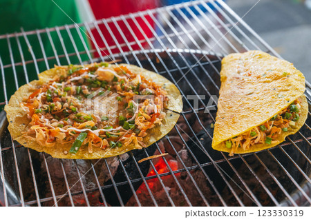 Vietnamese banh Xeo pancakes grilled at Asian street market in Vietnam. Traditional Vietnamese street food in Asia Vietnamese banh Xeo pancakes grilled at Asian street market in Vietnam. Traditional Vietnamese street food in Asia 123330319