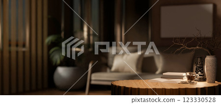 The round wooden table with decors in the middle, with blurry background of dark living room. The round wooden table with decors in the middle, with blurry background of dark living room. 123330528