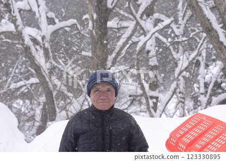 一位老人在雪地裡清理積雪 一位老人在雪地裡清理積雪 123330895