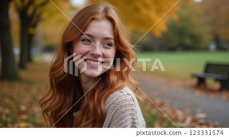 Young woman smiling joyfully in a park surrounded by autumn leaves Young woman smiling joyfully in a park surrounded by autumn leaves 123331574