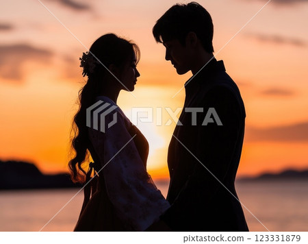 Silhouette of a young couple looking at each other and holding hands with a sunset in the background. Silhouette of a young couple looking at each other and holding hands with a sunset in the background. 123331879