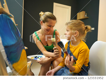 Teacher in workshop teched two girls how to assemble a thermo mosaic  123331952