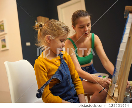 Teacher in workshop teched two girls how to assemble a thermo mosaic  123331954